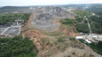 Vista aérea de pedreira ativa cercada por vegetação