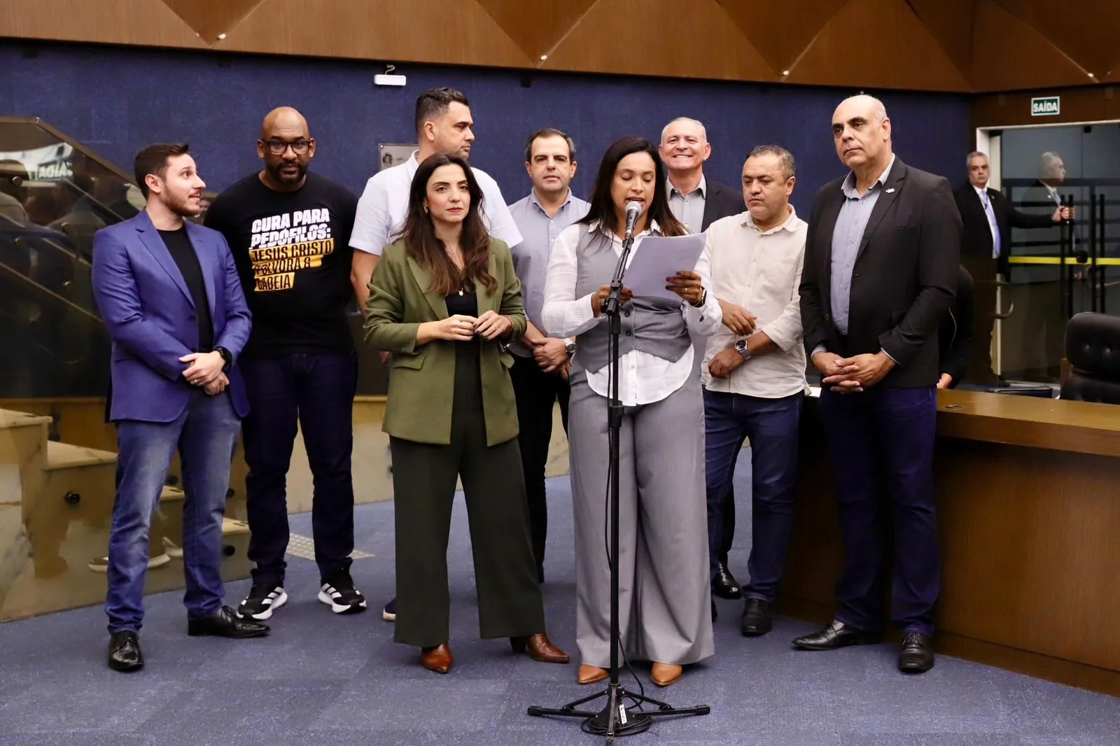 Vereadores da Frente Parlamentar Voz de BH apresentam projeto de lei sobre educação inclusiva em coletiva na Câmara Municipal de Belo Horizonte. Da esquerda para a direita: Lucas Ganem, Juninho Los Hermanos, Marcela Trópia, Arruda, Irlan Melo, Loíde Gonçalves (ao microfone), Maninho Félix, Cleiton Xavier e Helinho da Farmácia.