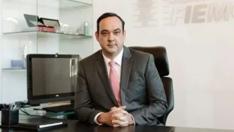 O presidente da Fiemg, Flávio Roscoe, de paletó e gravata, no seu gabinete de trabalho.