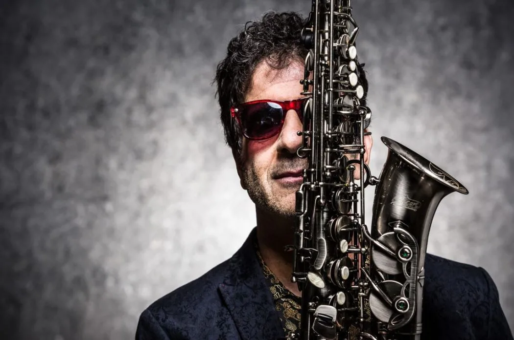 Foto do músico George Israel, ex-Kid Abelha, com saxofone em evidência, promovendo seu show “Baile do George” no Festival do Vinho, evento cultural gratuito com música ao vivo, gastronomia e vinhos internacionais em Belo Horizonte.