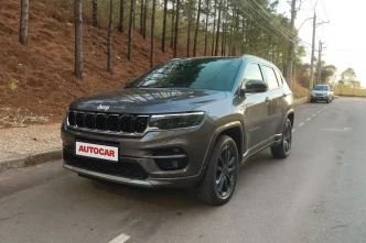 Jeep Commander Overland 2025 em tom grafite estacionado em rua arborizada, exibindo novo design frontal com faróis full LED, rodas de liga leve e placa personalizada Autocar, durante avaliação técnica para matéria automotiva.