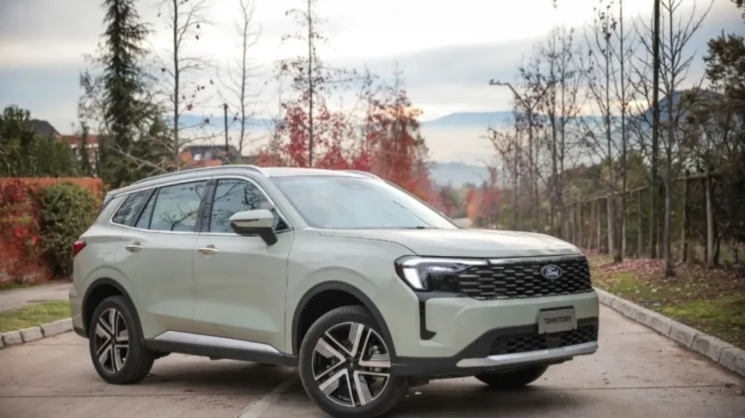 Novo Ford Territory 2026 Titanium na cor Verde Oásis estacionado em rua arborizada, destacando o design renovado com grade frontal imponente, faróis full-LED e rodas esportivas de 19 polegadas.
