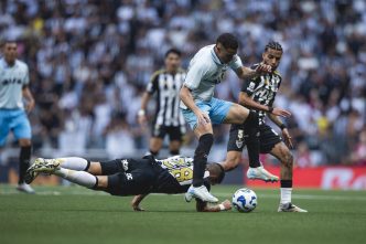 Jogadores do Atlético e do Grêmio disputam bola com intensidade no meio-campo, durante jogo no gramado da Arena MRV pelo Brasileirão 2025.