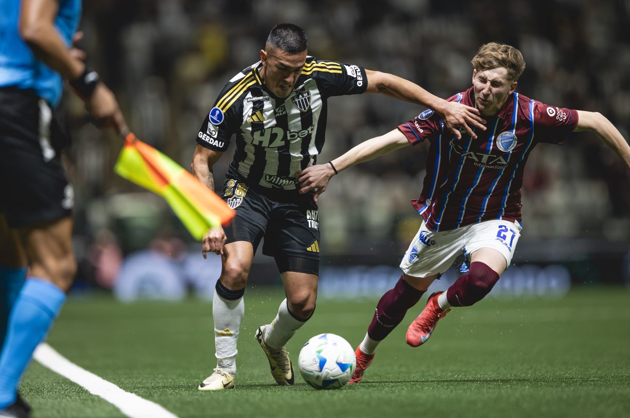 Jogador do Atlético-MG disputa lance acirrado com atleta do Godoy Cruz na Arena MRV durante jogo das oitavas da Sul-Americana 2025.
