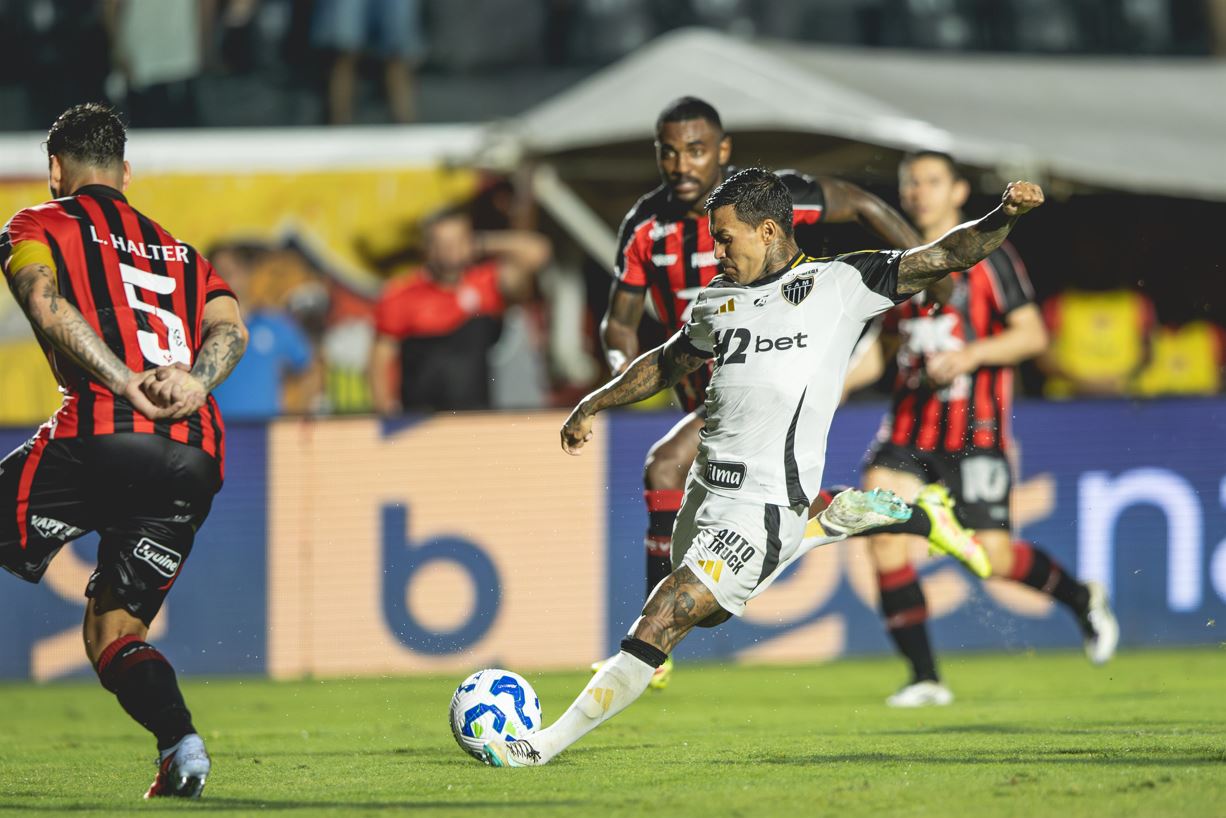 Jogador Dudu, do Atlético-MG, tenta finalização sob forte marcação de atletas do Vitória durante partida válida pela Série A do Brasileirão 2025, no estádio Barradão, em Salvador.