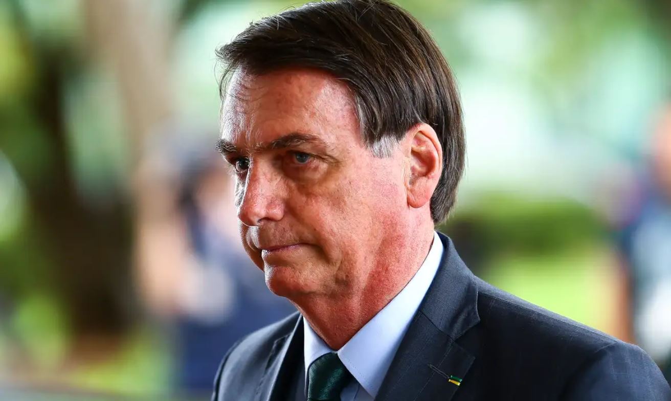 O ex-presidente Jair Messias Bolsonaro, com expressão tensa, usando paletó e gravata.