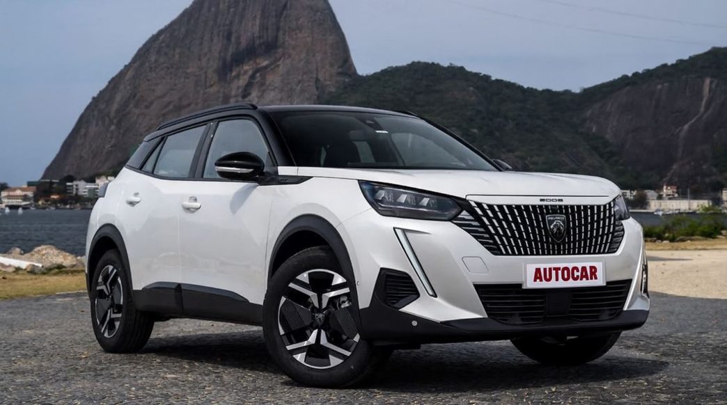 SUV Peugeot 2008 híbrido branco, posicionado em frente ao Pão de Açúcar no Rio de Janeiro.