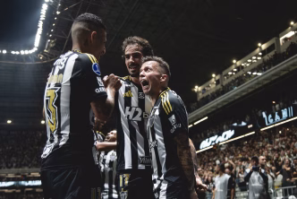Jogadores do Atlético-MG celebram efusivamente o segundo gol contra o Del Valle na semifinal da Copa Sul-Americana 2025, com a Arena MRV lotada ao fundo.