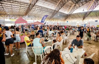 Público diverso aproveita a Oktoberfest em espaço coberto, com mesas lotadas, barracas de chope artesanal e decoração temática em BH.