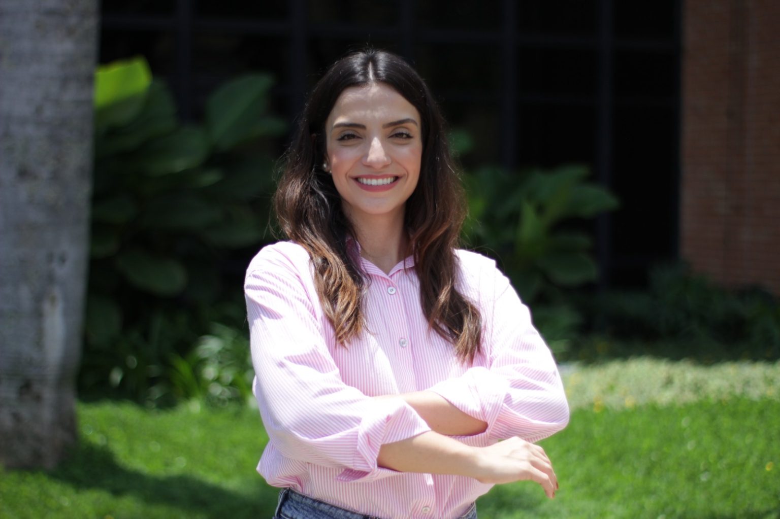 Vereadora Marcela Trópia sorri com os braços cruzados durante visita institucional a municípios do interior de Minas Gerais.
