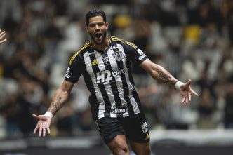 "Hulk comemora com intensidade seu gol histórico pelo Atlético Mineiro na Arena MRV, vestindo o uniforme alvinegro com patrocínios visíveis."